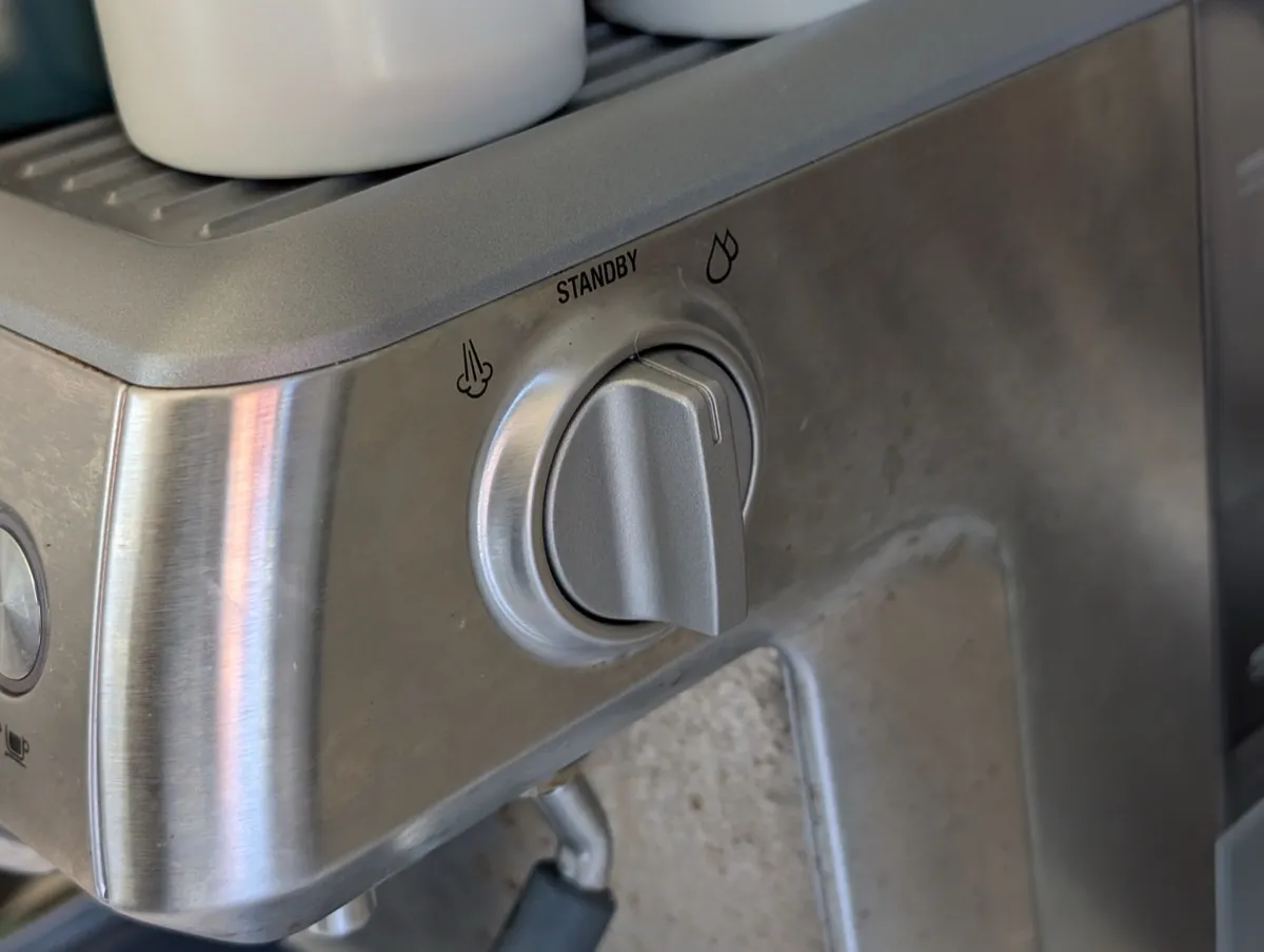 The steam/hot water selector knob on the right side of the Breville Barista Express, shown in the standby position