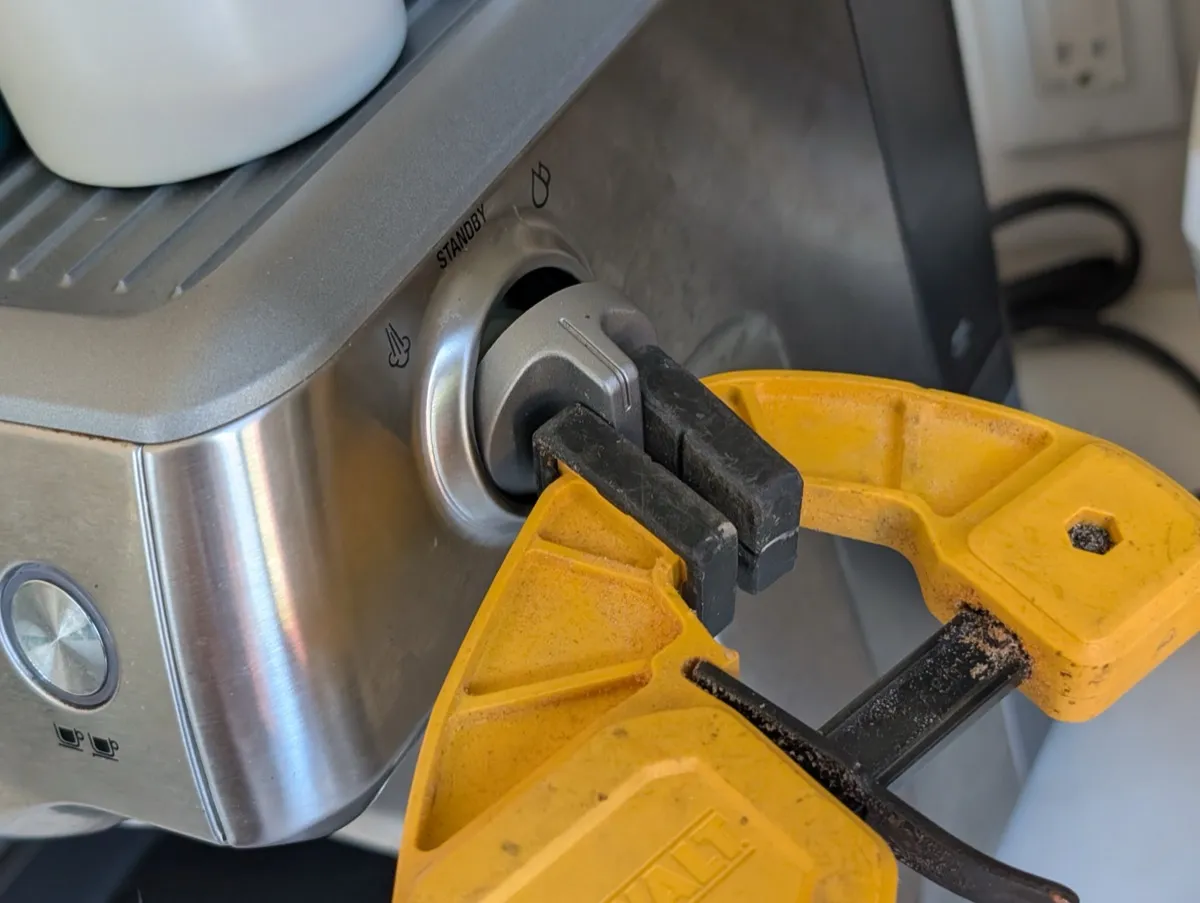 Using a quick clamp with rubber pads to grip and pull the knob straight off the machine