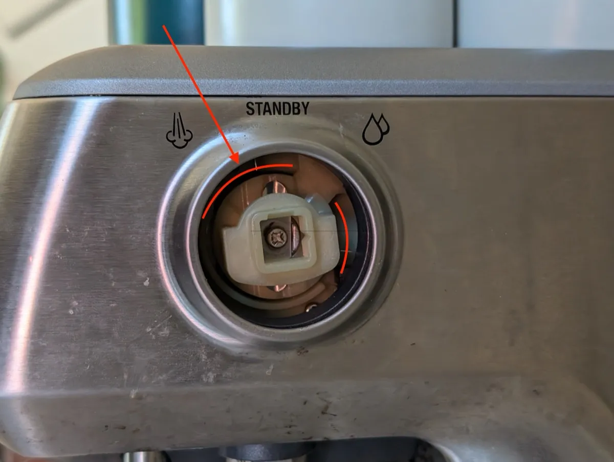The valve assembly with the knob removed. Red arrows point to the outer ring seal where buildup causes friction